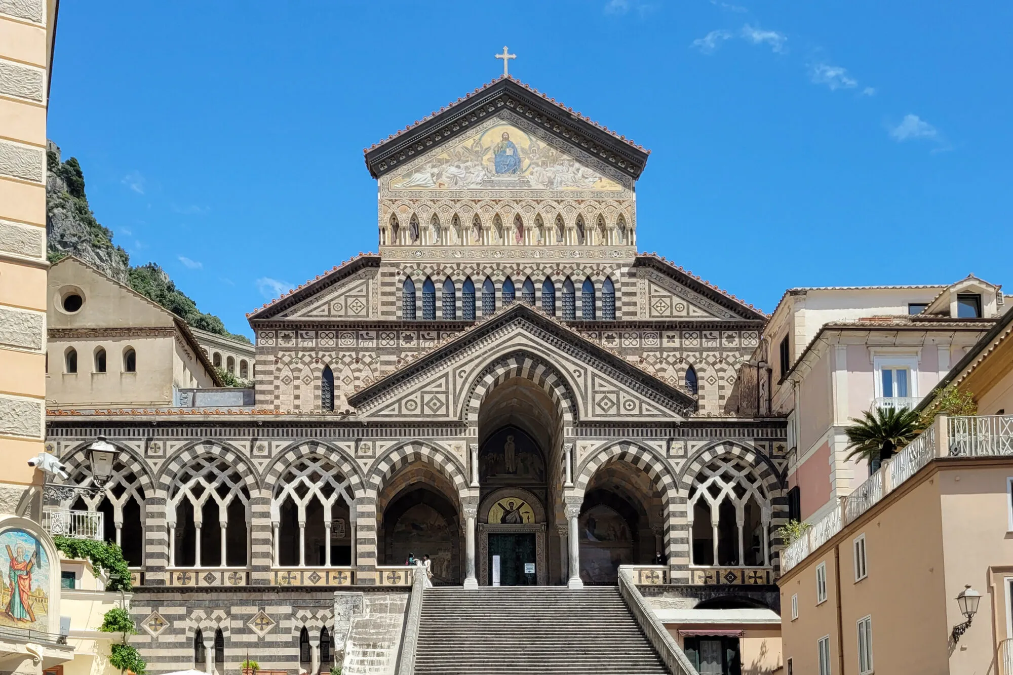 The striped facade and staircase of the Duomo di Amalfi above the town piazza