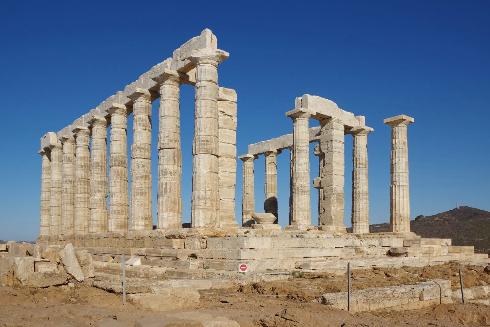 The Temple of Poseidon on its cliff at Cape Sounion, with the Aegean behind it