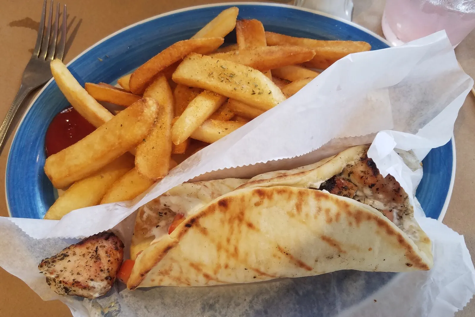 A chicken souvlaki pita with fries, the everyday street food of Athens