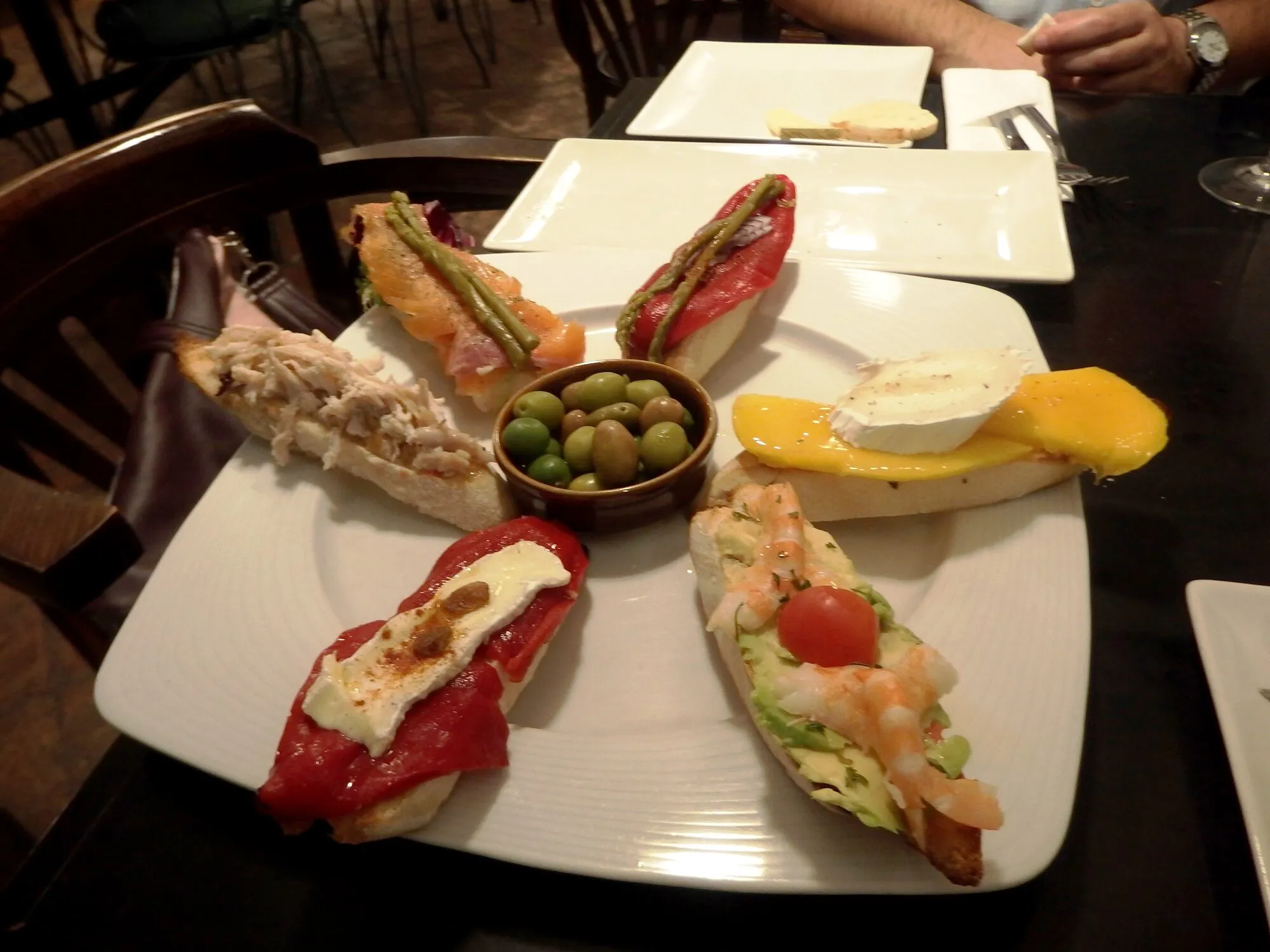 A plate of assorted Granada tapas and olives at a traditional bar in Granada, Spain