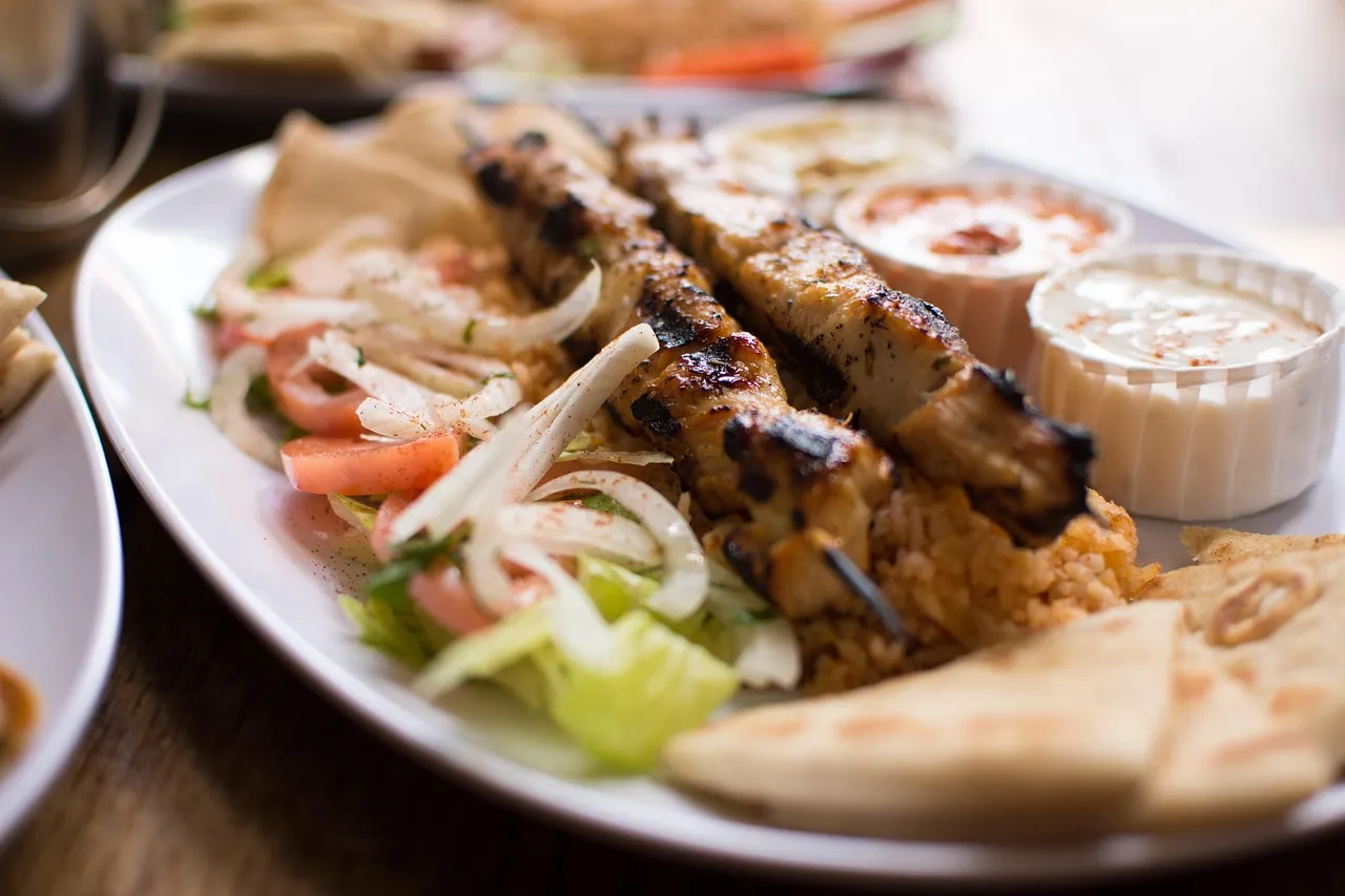 Greek souvlaki with pita, tomato and onion on a plate