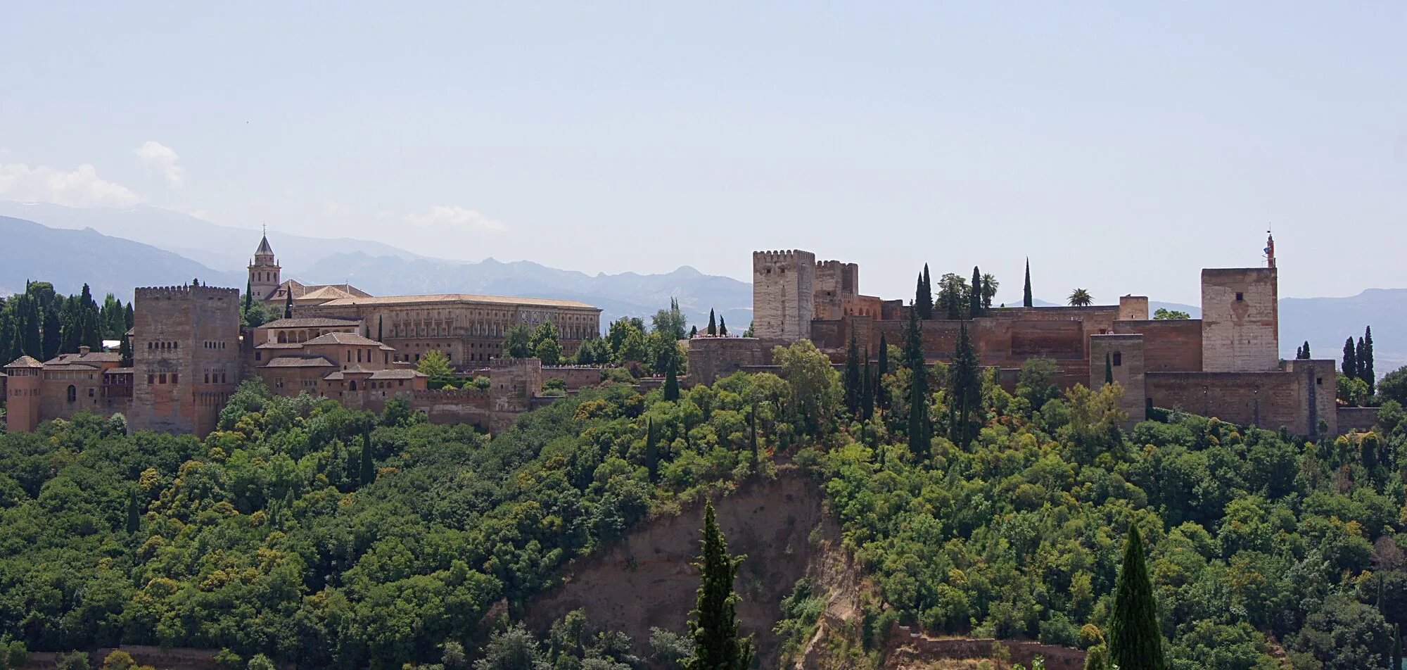 The Alhambra palace complex on its hill above Granada, Spain, seen from the Mirador de San Nicolas, with the Sierra Nevada behind