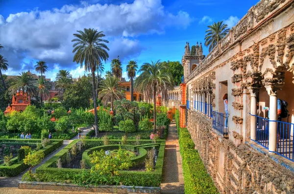 The Alcazar gardens in Seville, Spain, with orange trees and Moorish arches