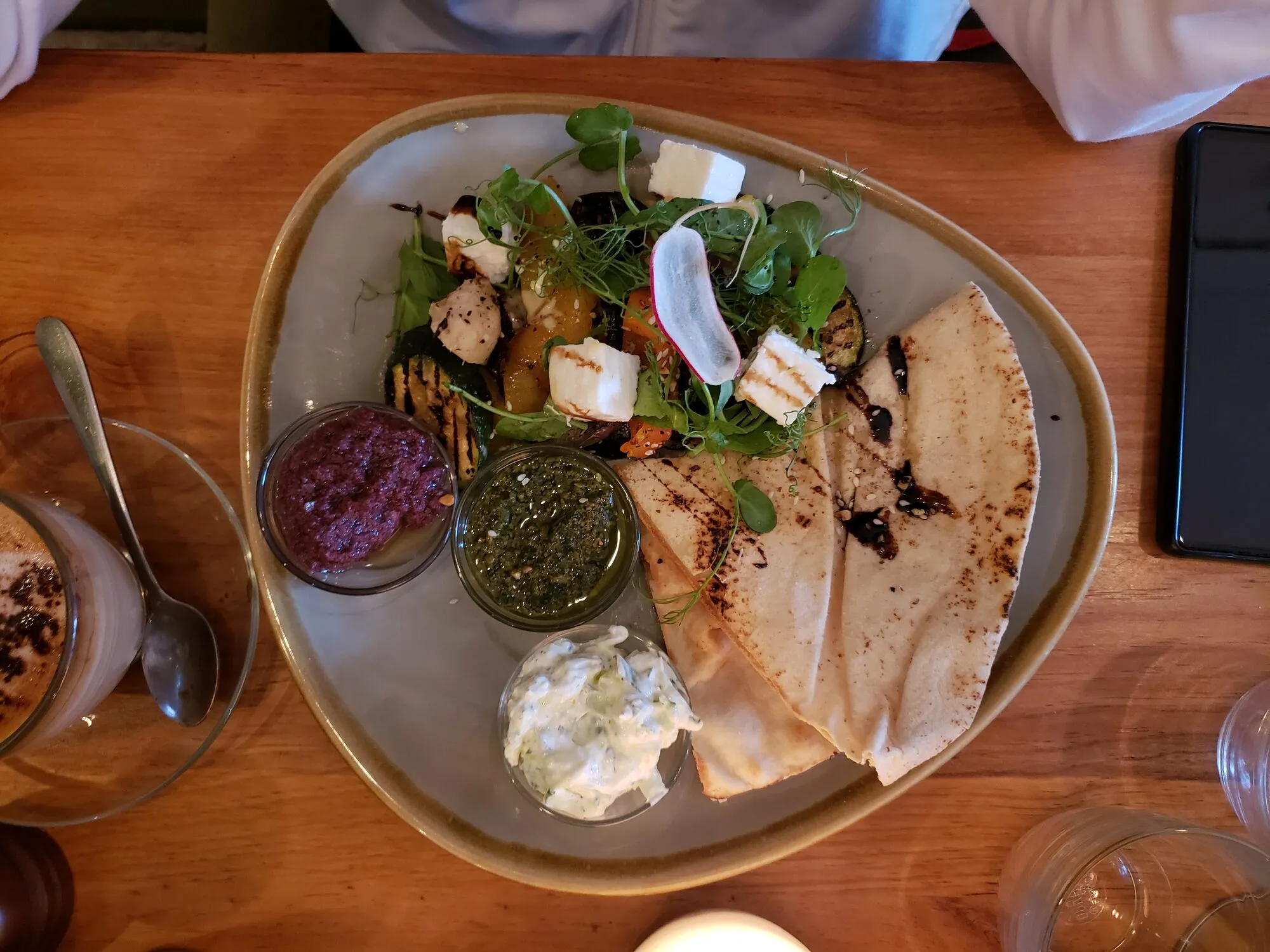 A shared table of mezze dishes with hummus, vegetable salads and dips served with warm flatbread