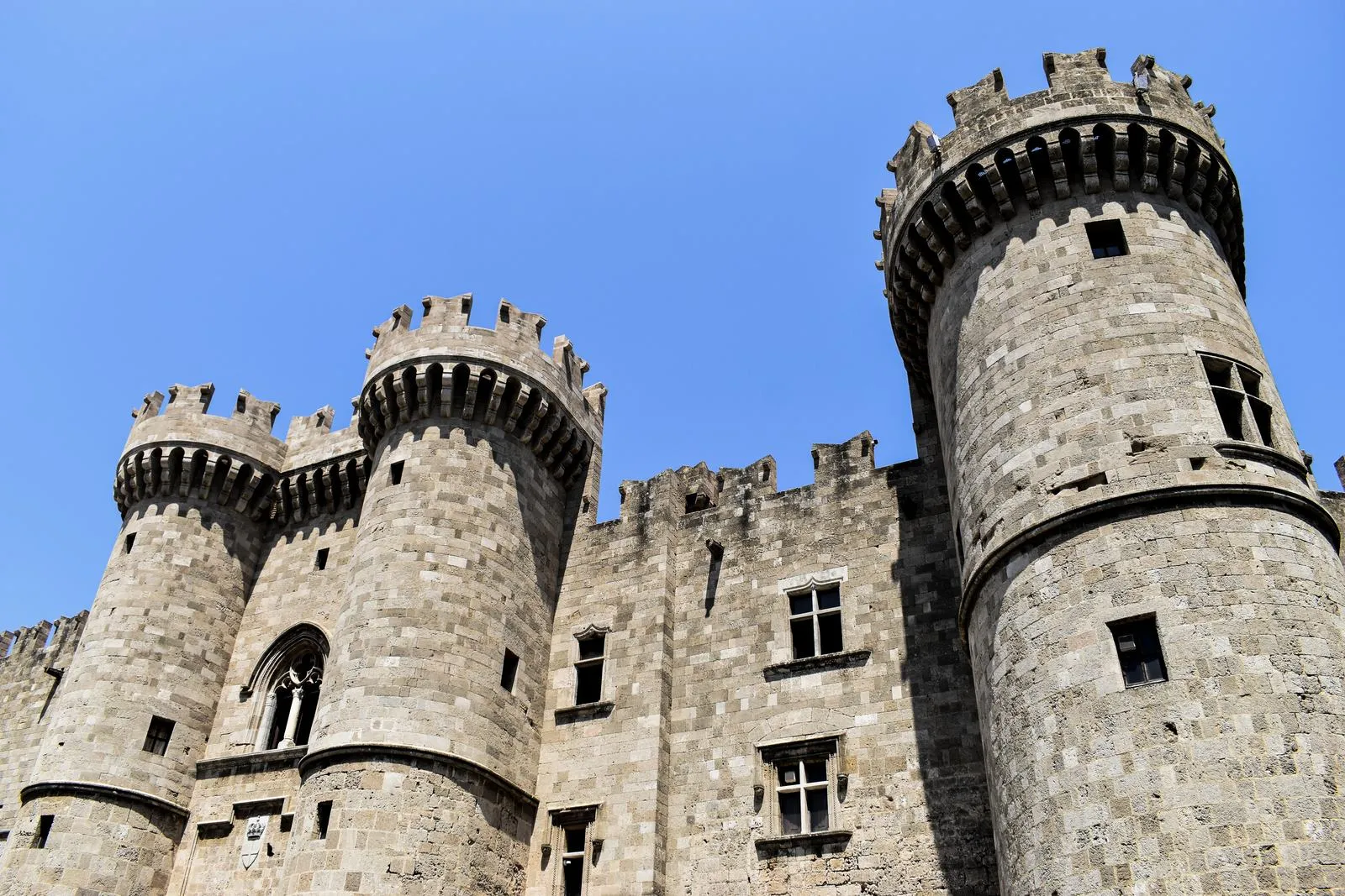 The crenellated towers and stone walls of the Palace of the Grand Master in Rhodes, Greece